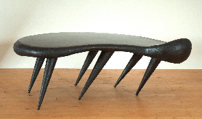 Besprechungstisch. Die Oberflche ist glatt und  so gewlbt, dass sie interessant aussieht, aber eben genug, um ein Weinglas darauf abzustellen oder darauf zu schreiben.